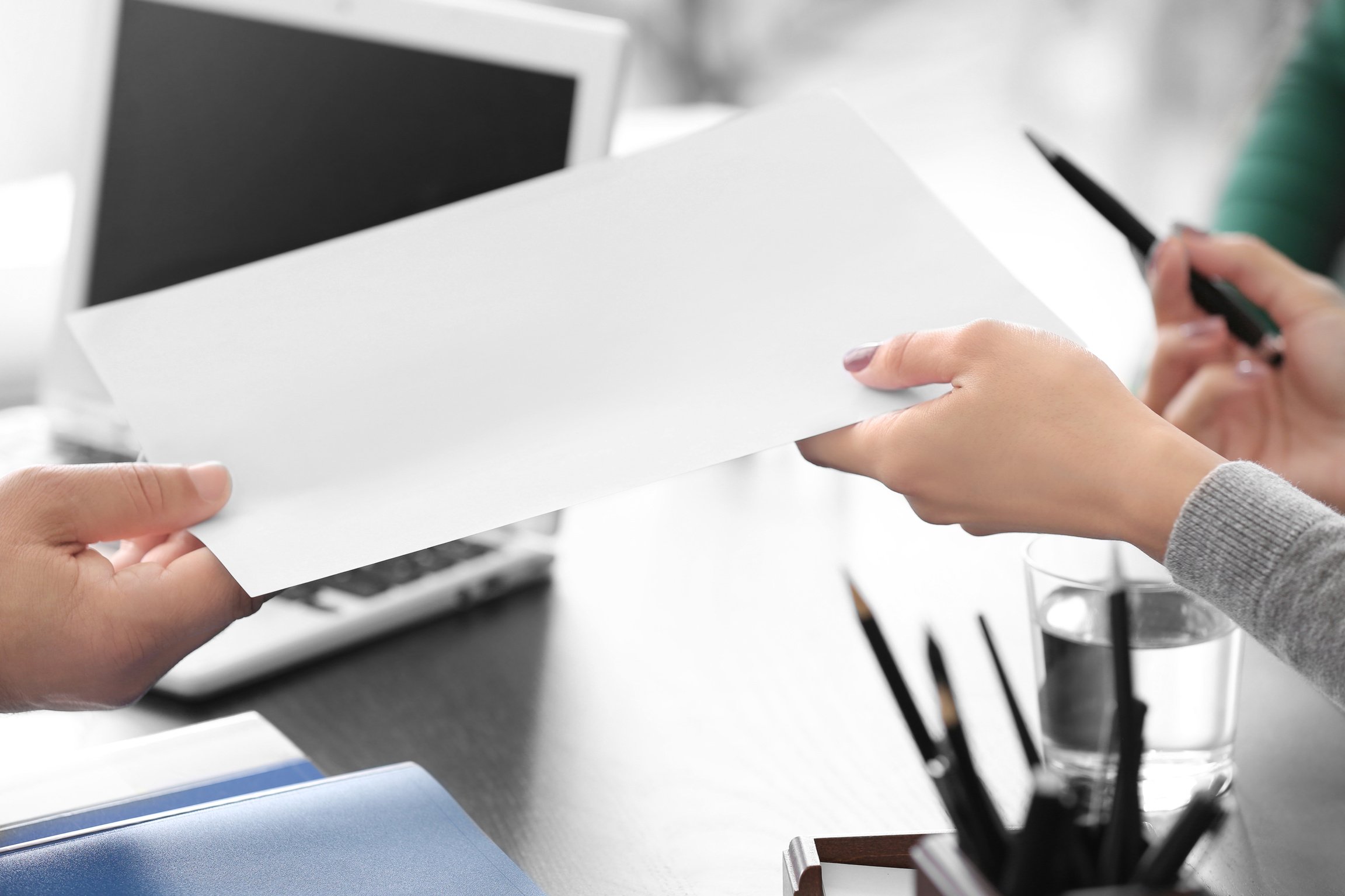 Notary Giving Sheet of Paper to Client in Office